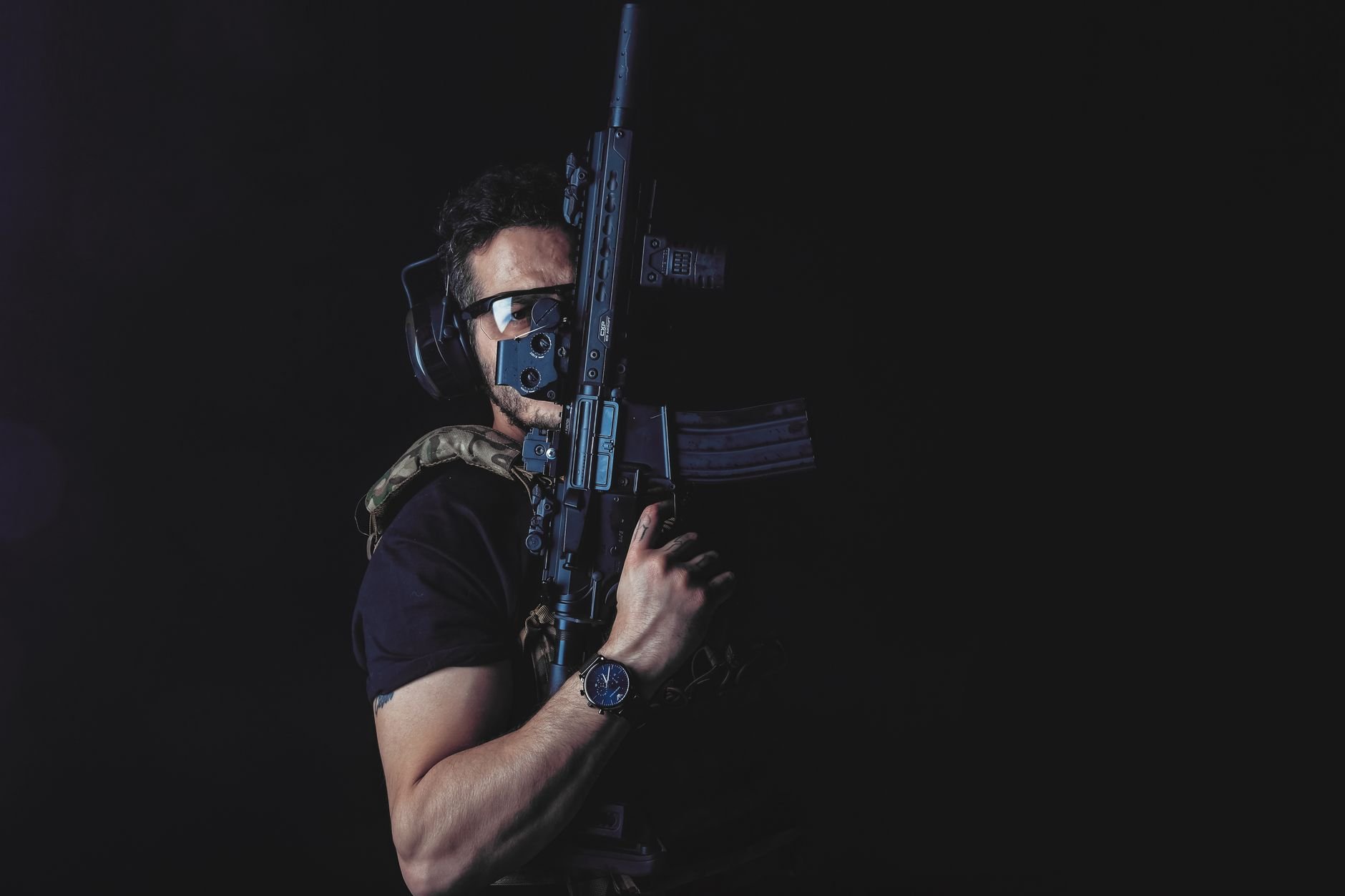 A soldier in tactical gear in a dark environment.